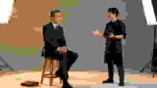 A professional photographer consults an executive in a studio for a corporate headshot session.